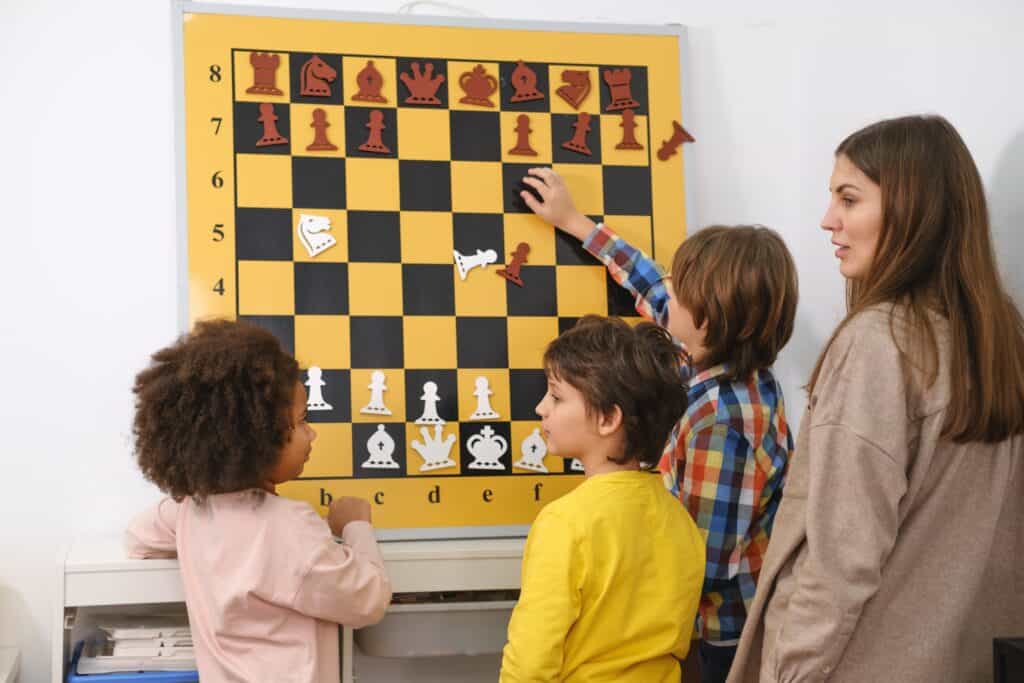 children setting up chess puzzle on a wall magnetic large chess board