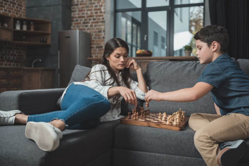 a boy and his young mother playing chess
